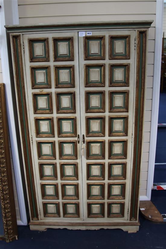 An Italian late 17th century style painted and parcel gilt panelled two door cupboard, H.171cm